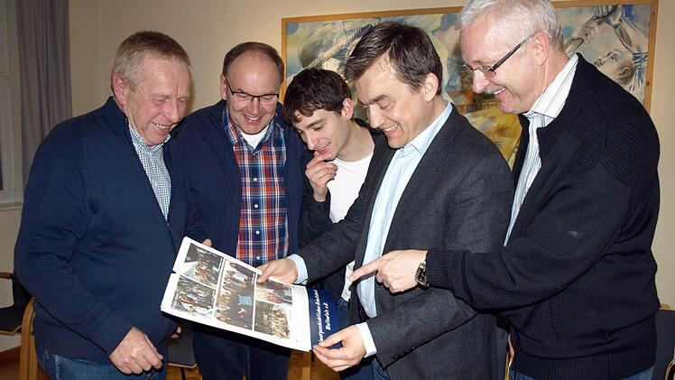 Interessiert betrachten Bürgermeister Jens Korn (Zweiter von rechts), Franz Behrschmidt (rechts) und (von links) Michael Förner, Dieter Müller und Thomas Weiß den neuen Wallenfelser Heimatkalender "Hinaus in die weite Welt".