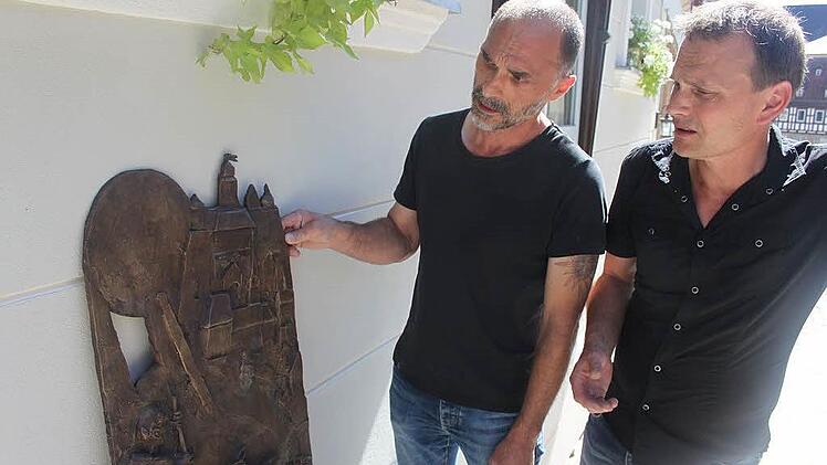 Johannes und Tobias Schreiber besprechen die Motive der einzelnen Bronzetafeln. Dabei werden Erinnerungen an ihren Vater wach. Foto: Veronika Schadeck