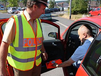 Lothar Manger, Verkehrssachbearbeiter bei der Bad Kissinger Polizei, kontrolliert nicht nur, ob Warnwesten im Auto sind, sondern empfiehlt auch, dass sie jederzeit greifbar aufbewahrt werden. Fotos: Ralf Ruppert