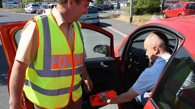 Lothar Manger, Verkehrssachbearbeiter bei der Bad Kissinger Polizei, kontrolliert nicht nur, ob Warnwesten im Auto sind, sondern empfiehlt auch, dass sie jederzeit greifbar aufbewahrt werden. Fotos: Ralf Ruppert