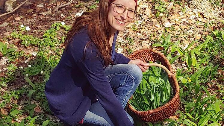 Kräuterführerin Katja Reith sammelt Bärlauch in einem Waldstück bei Bad Bocklet. Reith