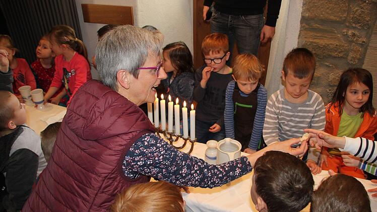 Die Vorschulkinder des St.-Franziskus-Kindergartens in Zapfendorf sind mit Annerose Simon beim Abendmahl im Ostergarten. Foto: Dunja Neupert