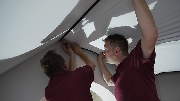 Am Donnerstag hieß es: weiterarbeiten. Christoph Neske (links) und Andreas Keilholz montieren eine Spanndecke. Foto: Rebecca Vogt