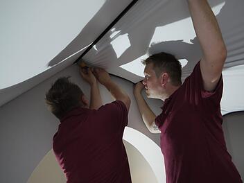 Am Donnerstag hie&szlig; es: weiterarbeiten. Christoph Neske (links) und Andreas Keilholz montieren eine Spanndecke. Foto: Rebecca Vogt