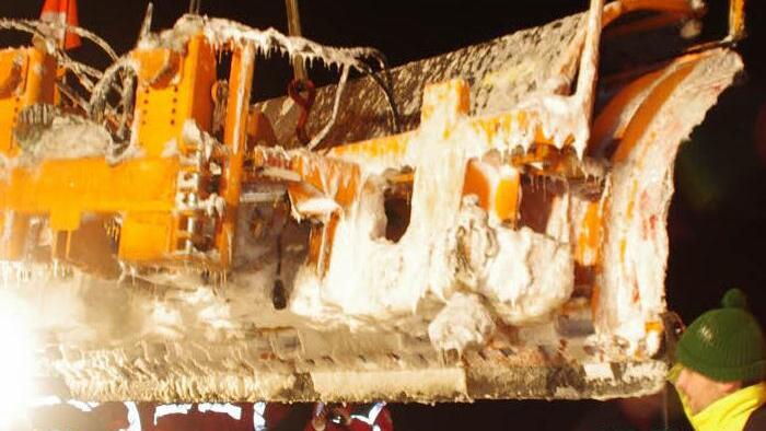 Mehrere Personen stabilisierten das Räumschild, als es angehoben wurde.