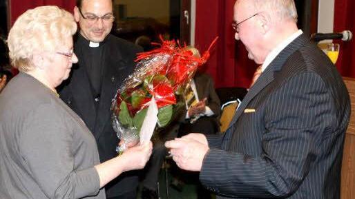 Kirchenpfleger Georg Simon überreichte der langjährigen Pfarrsekretärin Mathilde Wunder einen Blumenstrauß. Im Hintergrund Pfarrer Richard F. Reis.  Foto: Michael Wunder