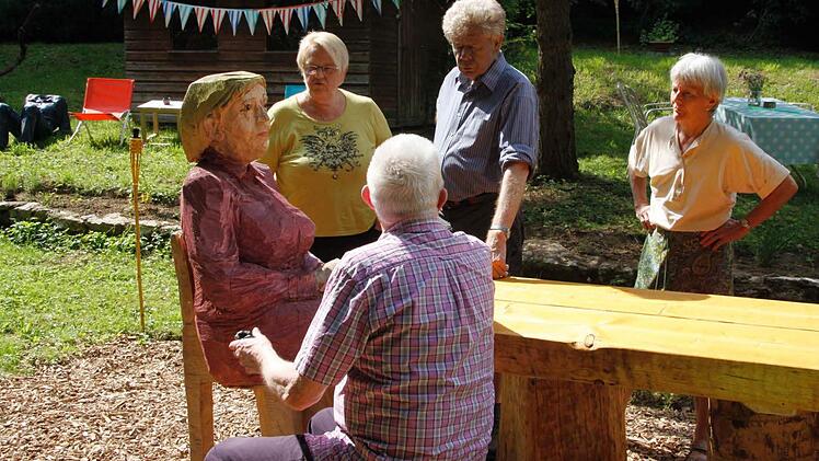 "Angela Merkel" am Kommunikationstisch mit (von links) Gemeinderätin Emilie Riedl, Paul Schelhorn mit Ehefrau