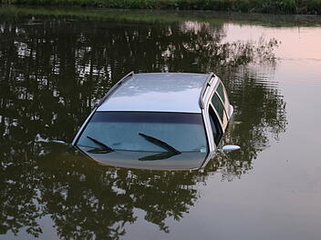 Auto rollt in Fischweiher