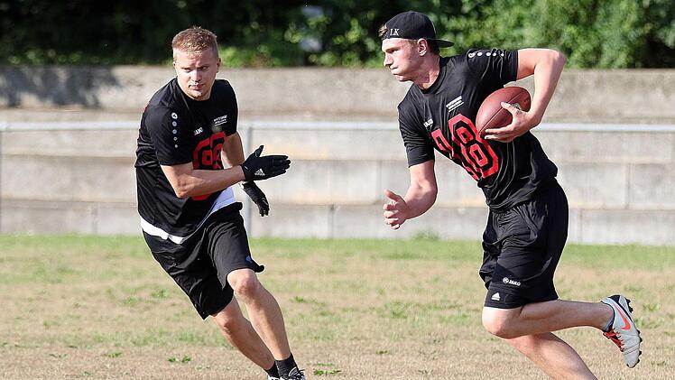 Quarterback Florian Cosack (rechts) aus Scheuerfeld probiert sich bei drückender Hitze an einem Laufspiel.  Fotos: Timo Geldner