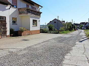 Staub und Lärm nerven die Anwohner dieser Schirnsdorfer Straße, die in Richtung Horbach führt. Bis der Ausbau im Rahmen der Dorferneuerung erfolgt, soll die Straße provisorisch asphaltiert werden. Foto: Evi Seeger