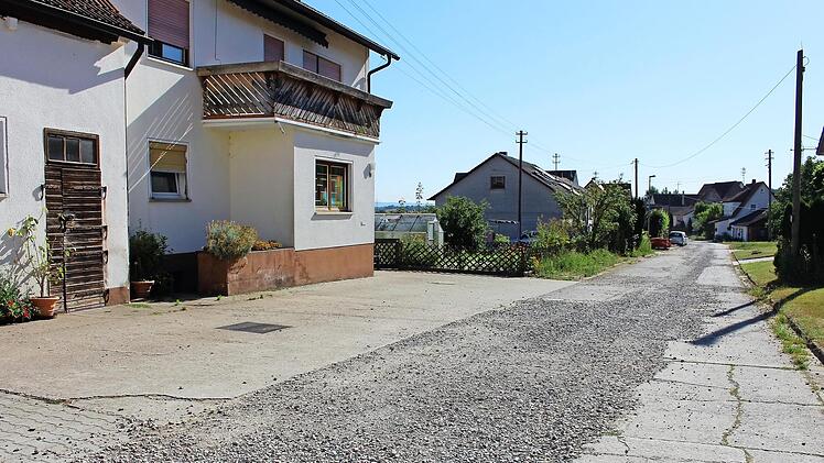 Staub und Lärm nerven die Anwohner dieser Schirnsdorfer Straße, die in Richtung Horbach führt. Bis der Ausbau im Rahmen der Dorferneuerung erfolgt, soll die Straße provisorisch asphaltiert werden. Foto: Evi Seeger