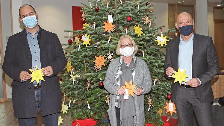 Benjamin Schmidt vom HPZ, Gerda Geiger-Glöckner (Vorsitzende des Inner Wheel Clubs) und Oliver Hofmann von der Sparkasse Coburg-Lichtenfels (v. l.) eröffneten in der Sparkasse die Weihnachtsaktion "Pflücken Sie einen Wunschstern vom Weihnachtsbaum". Foto: Thieret