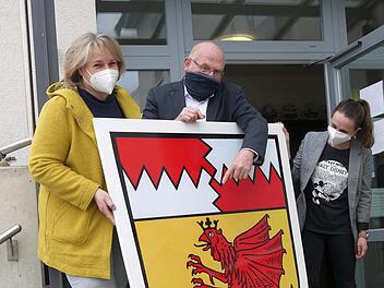 Da ist das Ding: Für die frisch sanierte Itzgrundhalle  haben Bürgermeisterin Nina Liebermann, Dieter Scherbel und Geschäftsleiterin Sandra Kob (von links) sogar ein XXL-Wappen zur Verfügung.
