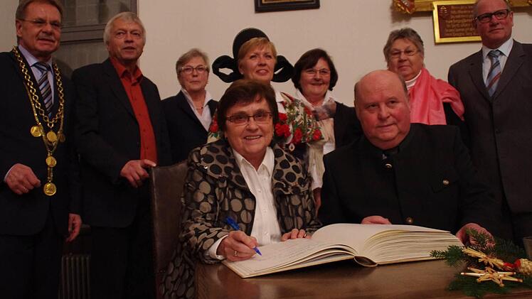 Mathilde Hutzl und Heinrich Reuß (v.) trugen sich als neue Träger der goldenen Ehrenmedaille ins goldene Buch der Stadt ein. Dahinter ist Bürgermeister Wolfgang Beiergrößlein (l.) mit den Bürgern zu sehen, welche die Medaille in Silber erhalten haben (v. l.): Ulrich Zeuß, Christel Thum, Pia Ender, Inge Schmidt, Elke Grötzner und Hubert Walter. Foto: Marco Meißner