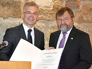 Alexander Büchel (l.) überreicht Wolfgang Holler die Ehrenurkunde. Foto: Petra Malbrich