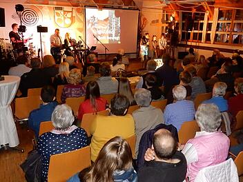 Blick ins Mehrzweckhaus mit Pfarrer Michael Maul als Moderator und der Gruppe "Worship Warriors" Foto: Reinhard Löwisch