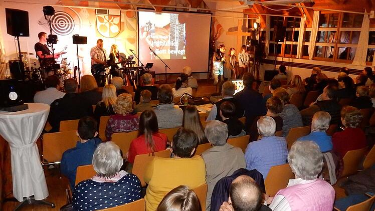 Blick ins Mehrzweckhaus mit Pfarrer Michael Maul als Moderator und der Gruppe "Worship Warriors" Foto: Reinhard Löwisch