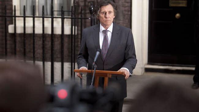 Tom Dawkins tritt nach dem Tod des Premierministers vor die Presse.