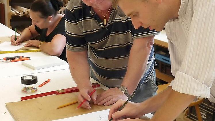 Klaus Bleimüller und Martin Königsteiner zeichnen den Grundriss einer Kastenkrippe. Fotos: Pauline Lindner