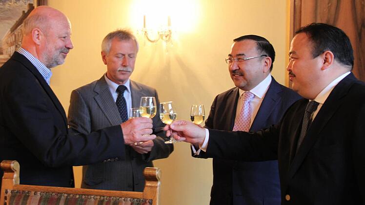 Auch eine Form von gespeicherter Sonnenenergie: Hans-Josef Fell, Ernst Stross, Dr. Nurlan Onzhanov und Akhat Alpysbayev (v. l.) ließen sich den Hammelburger Wein im Rathaus munden.