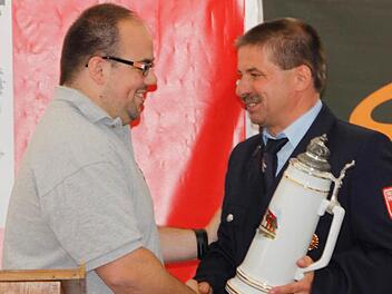 Feuerwehrvereinsvorsitzender Wolfgang Wiesenhütter (r.) nahm einen Fünf-Liter-Krug als Geschenk von der Patenwehr aus Igensdorf entgegen. Fotos: Reinhard Löwisch