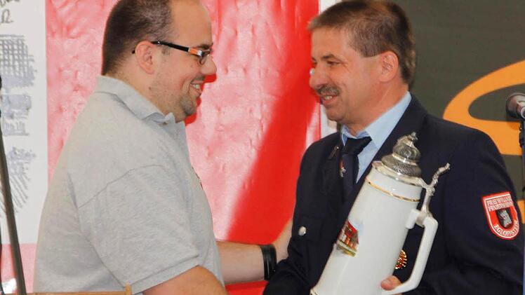 Feuerwehrvereinsvorsitzender Wolfgang Wiesenhütter (r.) nahm einen Fünf-Liter-Krug als Geschenk von der Patenwehr aus Igensdorf entgegen. Fotos: Reinhard Löwisch