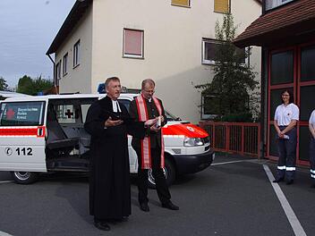 Pfarrer Gerald Munzert und Regionaldekan Thomas Teuchgräber segnen den Mannschaftstransportwagens vor. Mit im Bild sind (ab dritte von links) Bereitschaftsleiterin Thea Biesenecker und ihre Stellvertreterin Marina Zwingmann. Foto: Heike Schülein