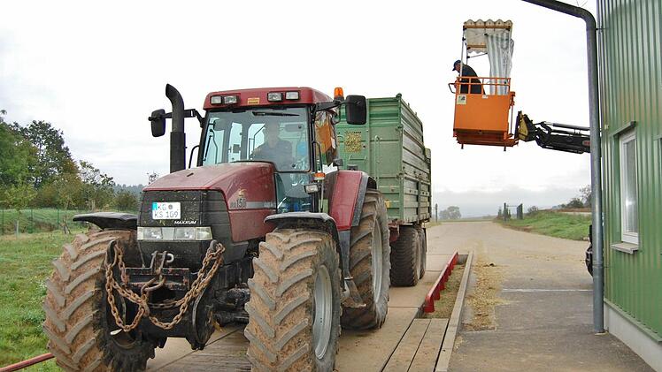 Während die Mais-Ladung gewogen wird, entnimmt Manfred Hofmann (rechts oben) die Proben zur Feststellung des Trockenmassegehalts. Foto: Sigismund von Dobschütz
