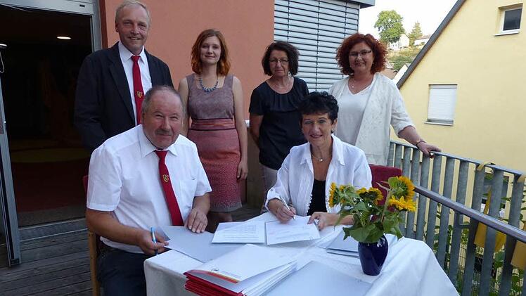 Bürgermeister Alfred Kolenda (sitzend, links) und Awo-Kreisvorsitzende Inge Aures (rechts) unterzeichneten die Verträge. Mit im Bild (stehend, von links) Dritter Bürgermeister Volker Matysiak, KiTa-Leiterin Anette Wanka, Awo-Geschäftsführerin Elisabeth Weith und Zweite Bürgermeisterin Doris Manz. Foto: Klaus-Peter Wulf