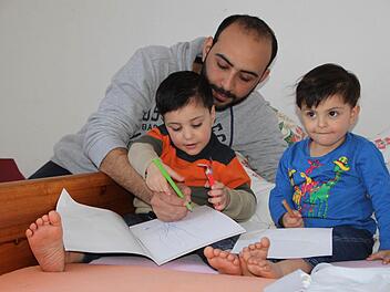Ein Stück Normalität in der Flüchtlingsunterkunft in Volkers: Mohamed Shaker Safeyah, Sohn Yasser (vier Jahre alt, links) und Tochter Farah (zwei Jahre alt, rechts) malen zusammen. Foto: Ulrike Müller