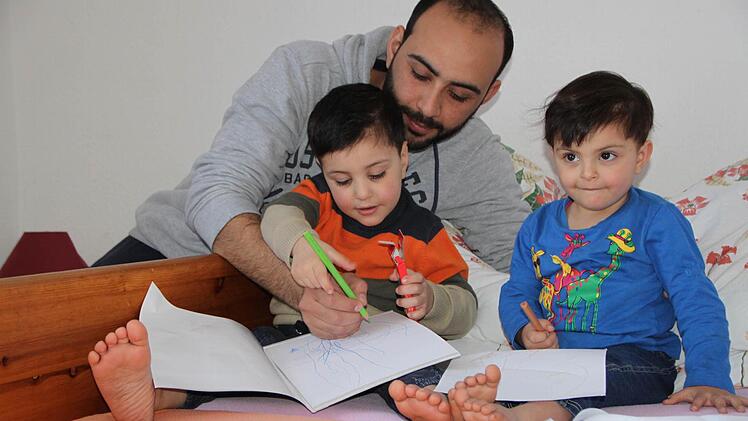 Ein Stück Normalität in der Flüchtlingsunterkunft in Volkers: Mohamed Shaker Safeyah, Sohn Yasser (vier Jahre alt, links) und Tochter Farah (zwei Jahre alt, rechts) malen zusammen. Foto: Ulrike Müller