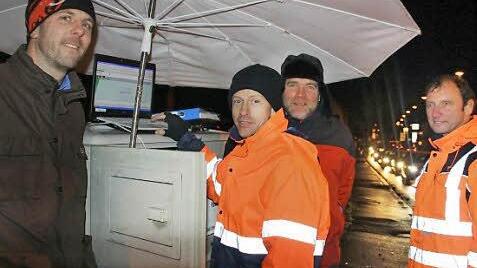 Per Laptop gegen Autoschlangen: Stefan Weißkopf (Staatliches Bauamt), René Goldmann (Ampelbaufirma), Walter Heussner (Projektleiter Verkehrsrechner beim Staatlichen Bauamt) und Dr. Michael Schenk vom beauftragten Planungsbüro (Software) trotzten am Montagabend dem Nieselregen und versuchten, den Verkehrsfluss auf der B 8 und ihren Nebenstraßen zu verbessern. Fotos: Diana Fuchs