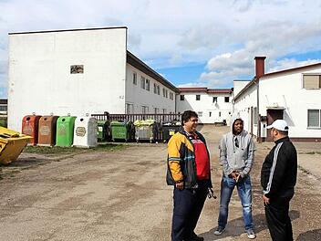 Aus vielen unterschiedlichen Nationen kommen die Asylbewerber, die in der Gemeinschaftsunterkunft in Höchstadt leben. Hier ein Kosovo-Albaner, ein Äthiopier und ein Libanese (von links). Sie sind gespannt, wie der Anbau an dem linken Gebäudeflügel werden soll.  Foto: Andreas Dorsch