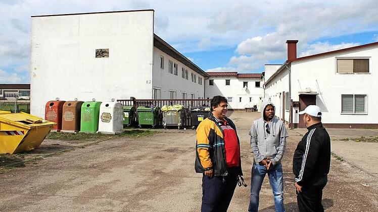 Aus vielen unterschiedlichen Nationen kommen die Asylbewerber, die in der Gemeinschaftsunterkunft in Höchstadt leben. Hier ein Kosovo-Albaner, ein Äthiopier und ein Libanese (von links). Sie sind gespannt, wie der Anbau an dem linken Gebäudeflügel werden soll.  Foto: Andreas Dorsch