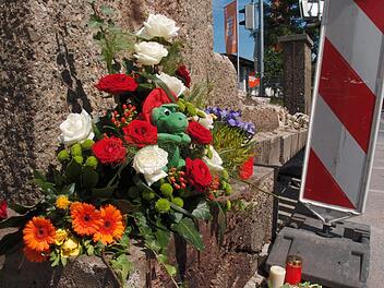 Blumen und Kerzen erinnern in der Neustadter Straße an den Unfall, bei dem ein 20 Jahre alter Feuerwehrmann starb. Foto: Jochen Berger