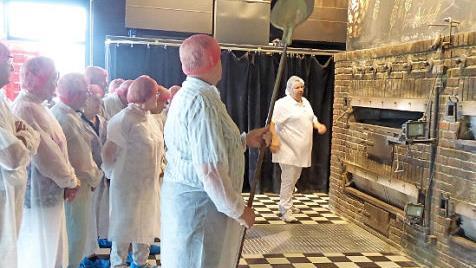 Die Hausener Senioren besichtigen in Hygienekleidung die "Brothaus"-Backstube in Rothenburg.  Foto: Gerda Wagner