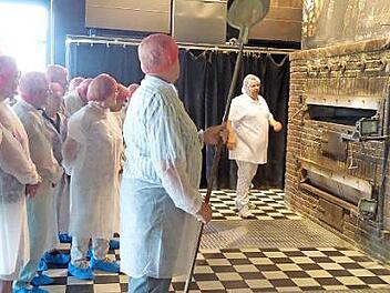 Die Hausener Senioren besichtigen in Hygienekleidung die "Brothaus"-Backstube in Rothenburg.  Foto: Gerda Wagner