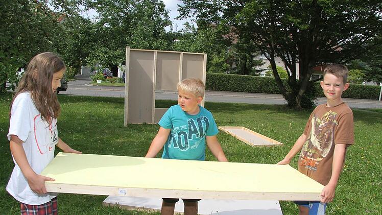 Gemeinsam schleppen Theo Bruhn, Felix Falk und Pascal Kober (alle 10) das schwere Hauselement.