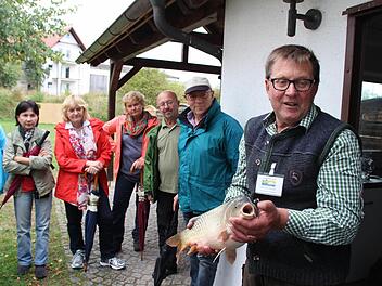 Leonhard Thomann (rechts) zeigte den Teilnehmern der Karpfenwanderung auch einen Schuppenkarpfen. Foto: Andreas Dorsch