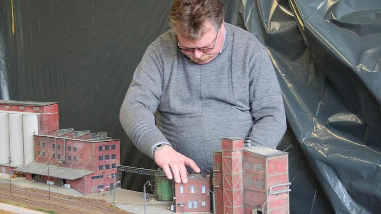 Olaf Brabandt von den Eisenbahnfreunden Halle stellt die Schuppen der Industriebahnanlage auf-
