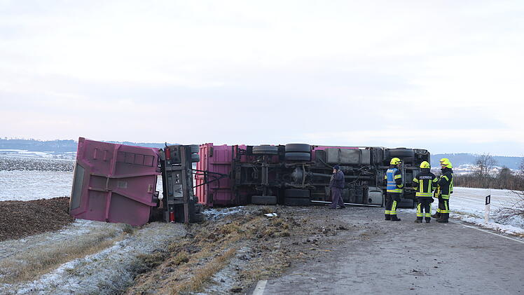 Lastwagen kommt von Stra&szlig;e ab und kippt um: Rindenmulch auf der Stra&szlig;e verteilt - Fahrer verletzt