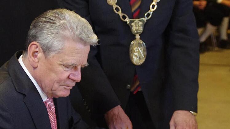 Bürgermeister Gerhard Wunder (r.) reicht Joachim Gauck das Goldene Buch der Marktgemeinde Steinwiesen. Foto: Marco Meißner