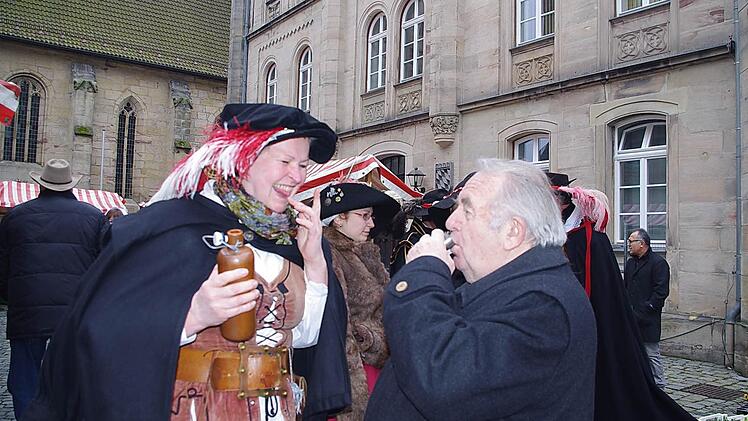 Gisela Lang (links) schenkt Likör an Heinz Hausmann aus.