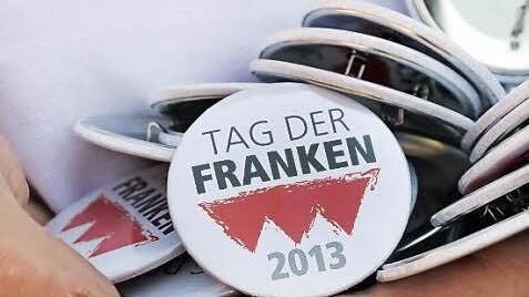 Bekenntnis zum Anstecken: Buttons mit dem Veranstaltungslogo.
