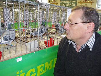 Taubenvater Joachim Volk freut sich über das beste Standardmännchen, beurteilt von den Preisrichtern nach Aussehen und Schönheit. Fotos: Heike Schülein