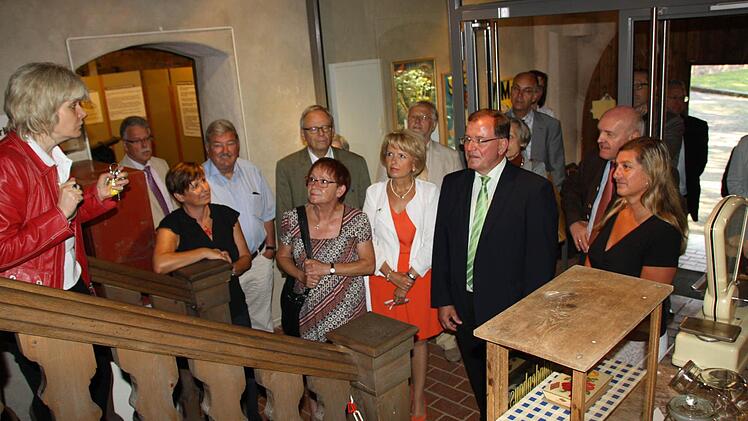 Museumsleiterin Annette Späth (links) führt Mitglieder des Bezirkstages durch das Volkskundemuseum. Aus Späths Sicht herrscht durchaus Handlungsbedarf in den drei Aschacher Museen, die laufenden Kosten könnten aber nur in begrenztem Maß gesenkt werden. Foto: Ralf Ruppert