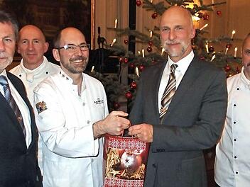 Die Kissinger Köche (von links) Erich Matejsek, Michael Seuffert, Jochen Wehner und Johannes Werner überreichen OB Kay Blankenburg (2. von rechts) ein "Symbol-Päckchen" ihrer Weihnachtshilfe. Foto: Klaus Werner