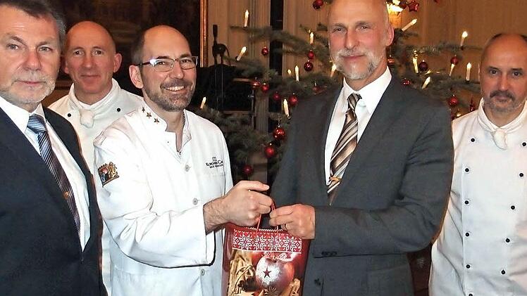 Die Kissinger Köche (von links) Erich Matejsek, Michael Seuffert, Jochen Wehner und Johannes Werner überreichen OB Kay Blankenburg (2. von rechts) ein "Symbol-Päckchen" ihrer Weihnachtshilfe. Foto: Klaus Werner