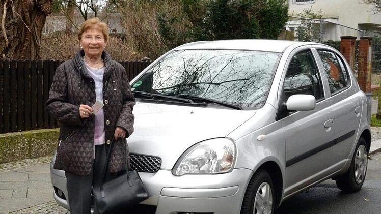 Rentnerin Christa Fischer steht vor einem silbernen Mazda und hält ihren Führerschein in der Hand. Das zweitletzte Auto, das sie gefahren hat, sah genauso aus. Ihr letztes Auto, das sie zu Schrott gefahren hat, war das gleiche Modell - aber in rot. Experten fordern verpflichtende "Feedbackfahrten" für Senioren. Foto: Anne-Sophie Galli/dpa