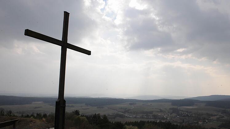 VoccawindDas Kreuz gemahnt an das Nahen der Karwoche, in der die Christen  auch über die Endlichkeit des Lebens nachdenken. Zugleich ist es  ist es Symbol für die Unendlichkeit der göttlichen Kraft. Ins Unendliche zu führen scheint  auch der Ausblick vom Zeilberg aus über den Weisachgrund und die Haßberge. Ronald Rinklef